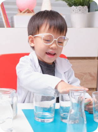 Preschooler in lab coat conducting science experiment