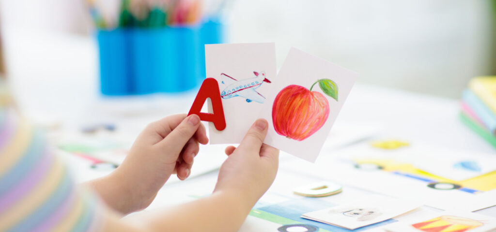 Child using visuals like flashcards to learn the alphabet. 