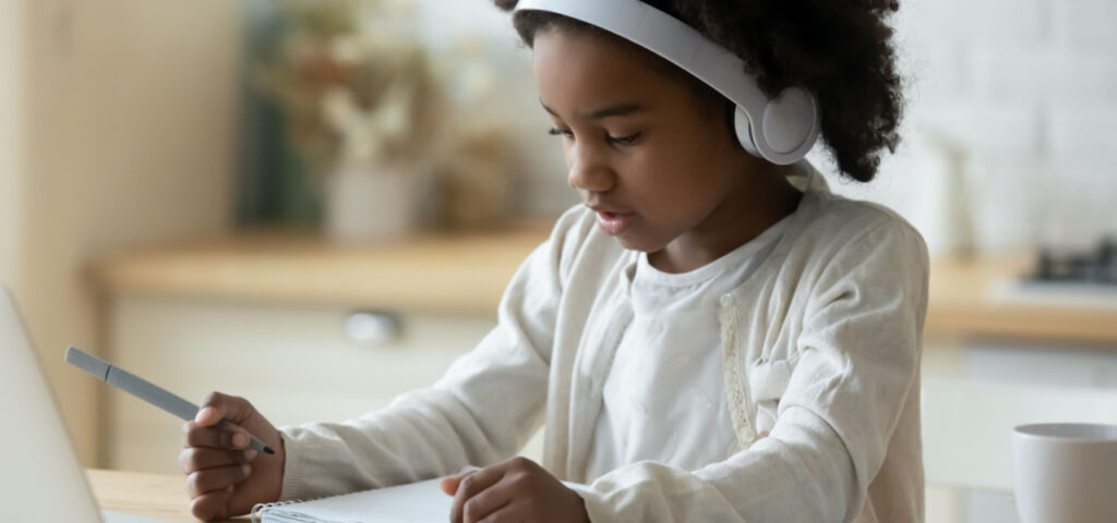 Child using headphones to learn in an auditory manner. 