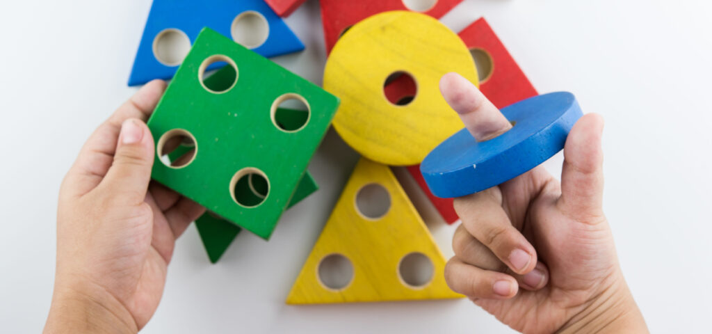 Colorful shaped blocks with holes in them used for hands on math learning. 