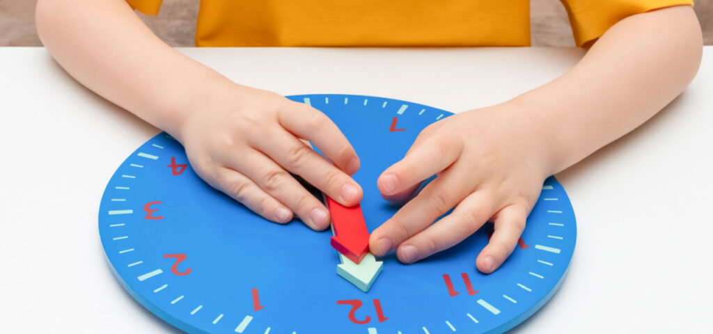 child using a wooden clock to help with tactile learning